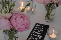 pink peonies in clear vases, pillar candles in clear candleholders and chalkboard menus for a chic and lovely summer wedding table