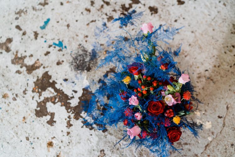 The wedding bouquet was done with super bright blooms of all colors, with berries and blue leaves