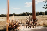 06 The wedding arch was a copper one, with lush florals, pampas grass and pillar candles