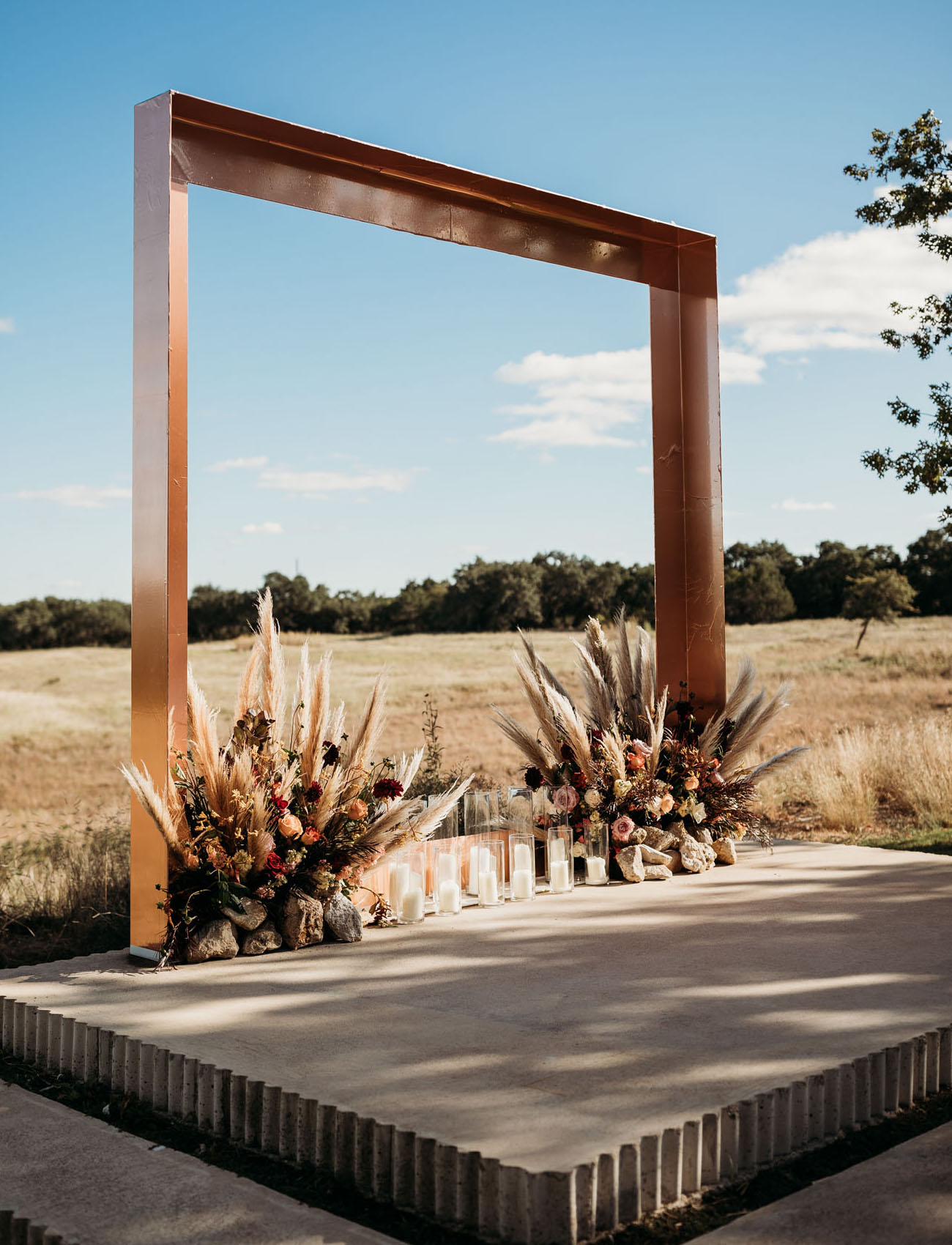 The wedding arch was a copper one, with lush florals, pampas grass and pillar candles