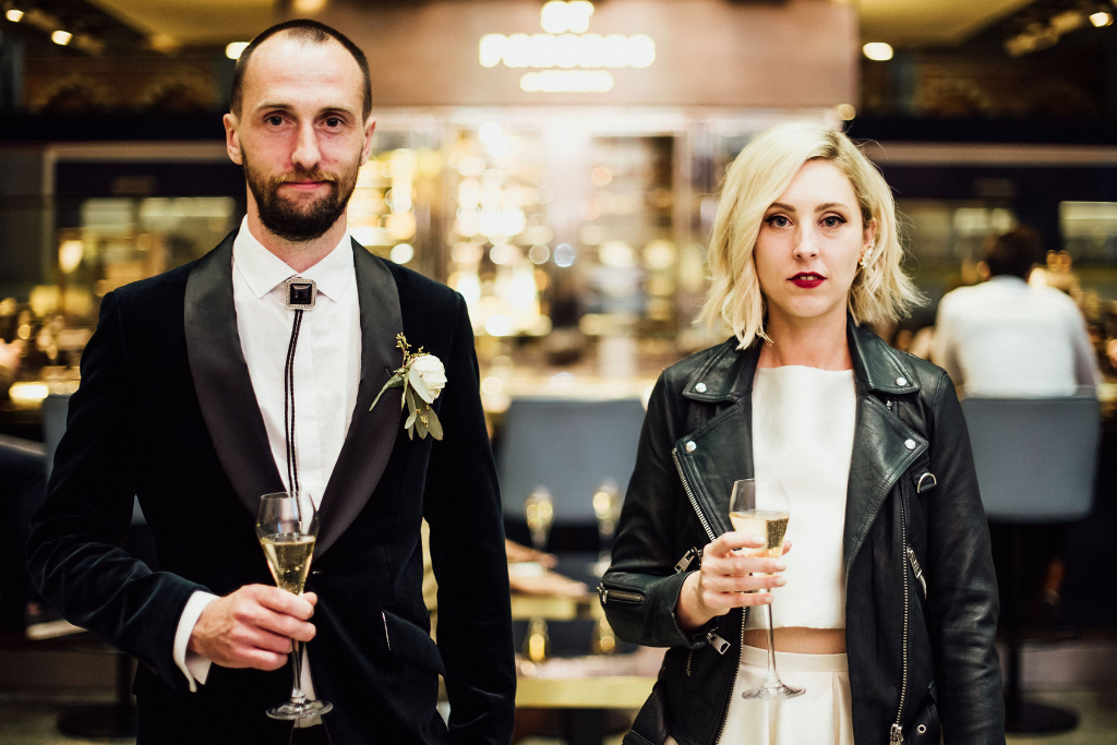 bride in a leather jacket looks cool in an art deco space