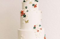 09 The couple served a white wedding cake with white, red and green blooms and gold butterflies