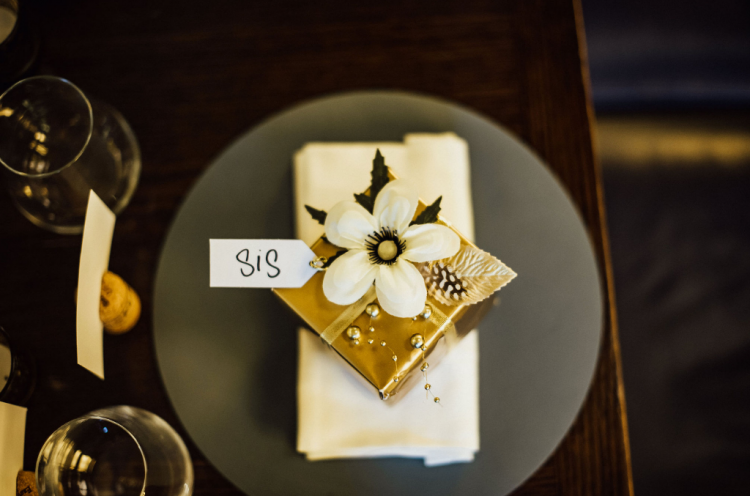 Each place setting was marked with a gold favor box with faux blooms and feathers