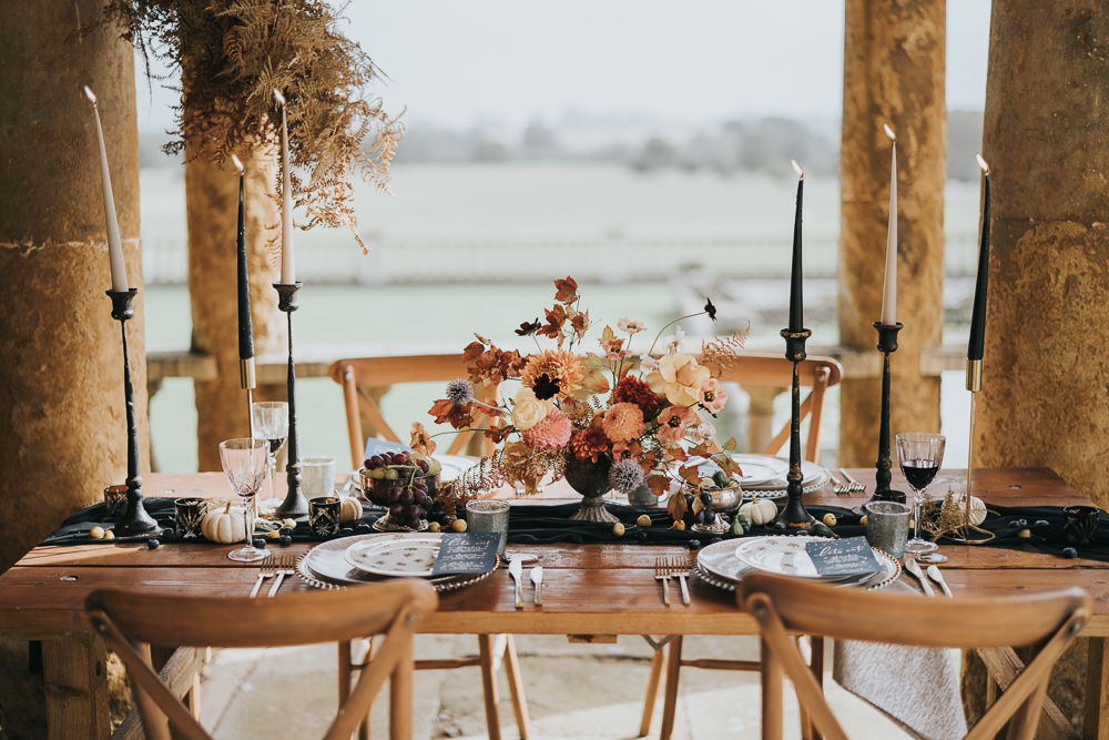 The wedding tablescape was very refined, with a black runner, black candles, bold fall blooms and fruits