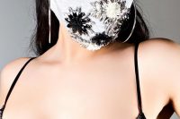 25 a grey face mask accented with neutral and black rhinestones and a fabric flower is a bold statement idea