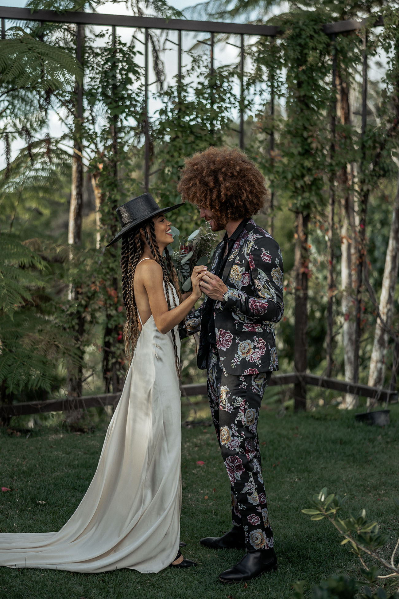 The groom was wearing a black floral suit, a black shirt and boots and his Afro hair perfectly finished off his look