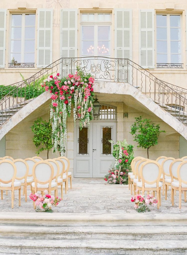 There was a gorgeous ceremony space with greenery and bright pink blooms and refined chairs