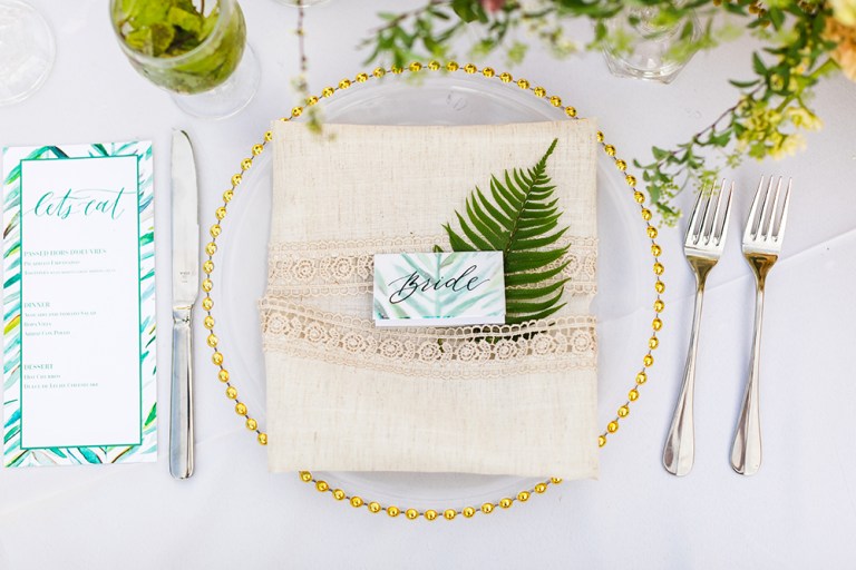 The place setting was done with a gold edge plate, a linen lace napkin and bright tropical stationery