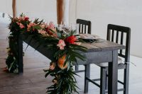 09 The sweetheart table was uncovered, with lush leaf garlands and bold blooms and candles