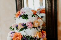 12 The gorgeous bright wedding cake was accented with orange, blush and white flowers and lavender