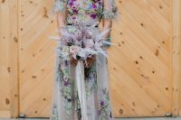 a blush A-line wedding dress with green, purple, pink embroidery all over the dress, an illusion bodice and short sleeves