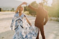 a bold blue boho floral embroidery wedding dress with cut bell sleeves, tassels and a train is a chic option