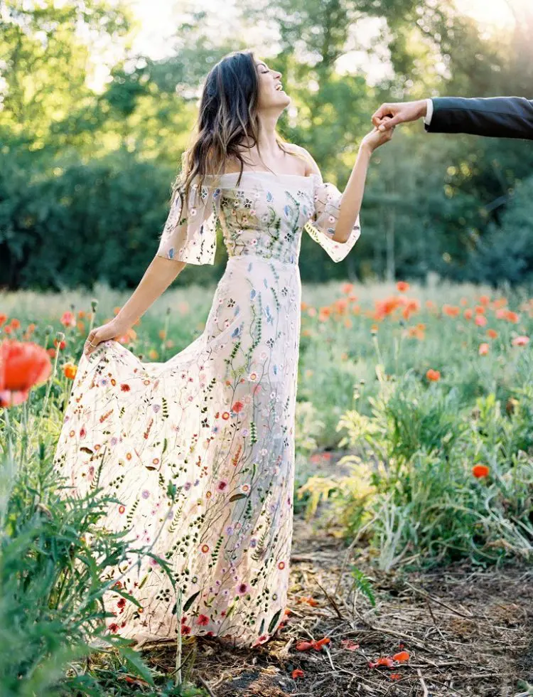 a romantic off the shoulder sheath wedding dress with an illusion skirt and wildflower embroidery in bold colors