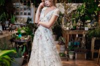 a very romantic A-line wedding dress with subtle pink and white floral embroidery for a delicate and enchanting bridal look