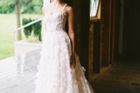 02 The first wedding dress was a breathtaking Al-line floral applique wedding gown with straps and a train