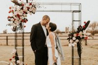 03 The metal wedding arch was decorated with blush and red blooms and dark leaves