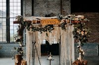 03 The wedding arch was done with macrame, greenery, a sign and with tree sutmps around