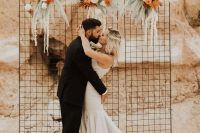 04 The wedding backdrop was a grid with rust-colored florals and green pampas grass