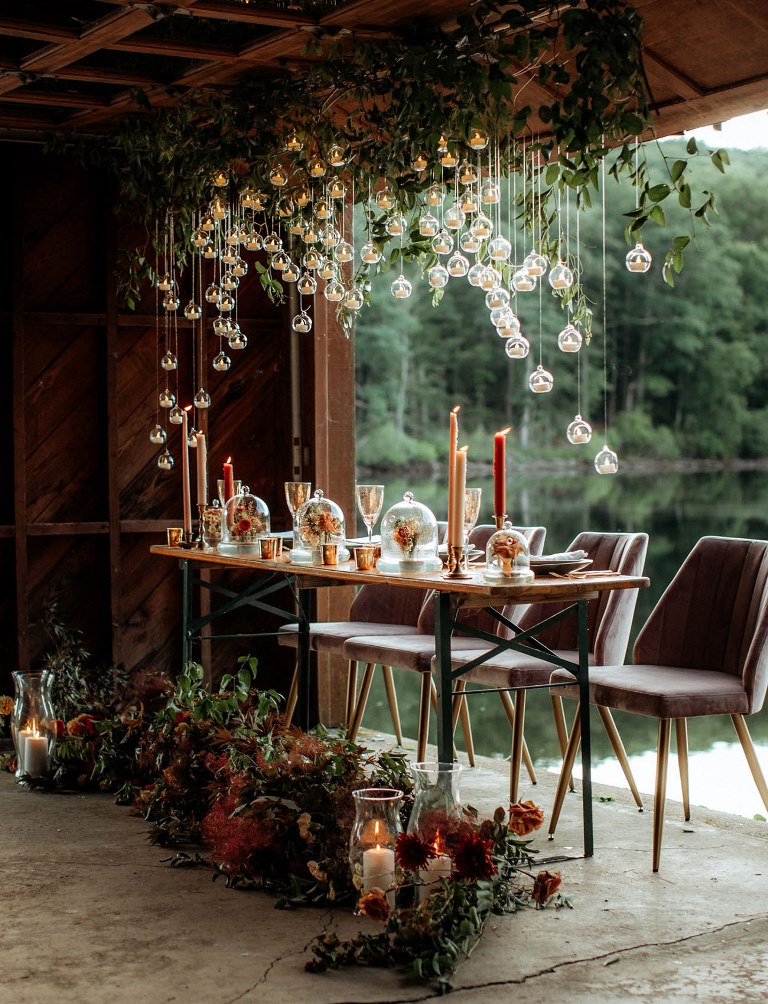 The wedding reception was magical and breathtaking, with lush foliage and hanging candles, bold candles and blooms in cloches