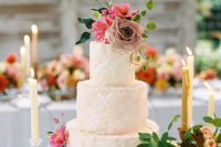 08 The wedding cake was a textural blush one, with greenery and blooms and candles around