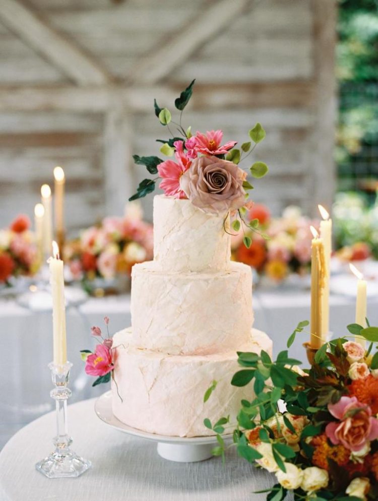 The wedding cake was a textural blush one, with greenery and blooms and candles around