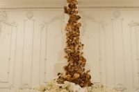 09 The wedding cake was a white one, decorated with gilded foliage and was palced on a flower covered stand
