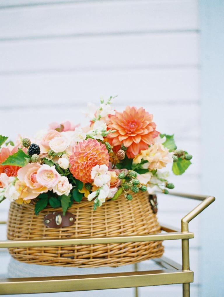 This basket floral arrangement is real essence of summer, with bright and blush blooms, leaves and berries