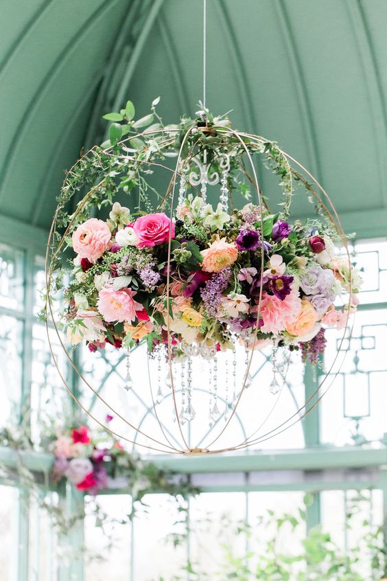 a refined floral chandelier of a sphere, crystals, bright blooms and greenery is a great solution for a fairy tale wedding