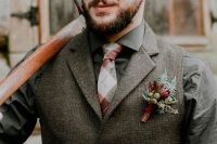 a grey tweed suit and a shirt, a printed tie and a bright boutonniere for an elegant yet boho look