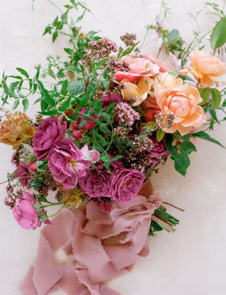 The weding bouquet was done with bold blooms, greenery and pink ribbons