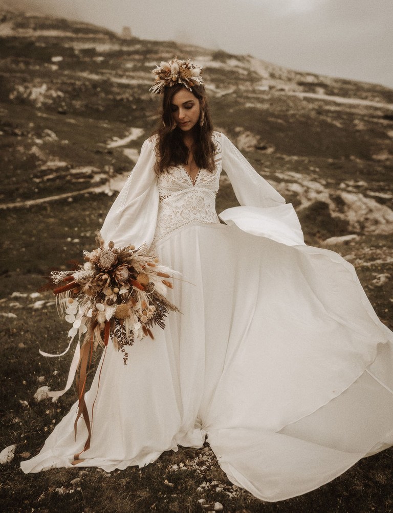 The bride was wearing a boho wedding dress with puff sleeves, a boho lace bodice and a plain skirt plus a floral headpiece