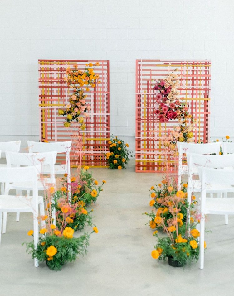 The wedding ceremony space was done with a bold wedding backdrop with strong color blocking, bright blooms and greenery
