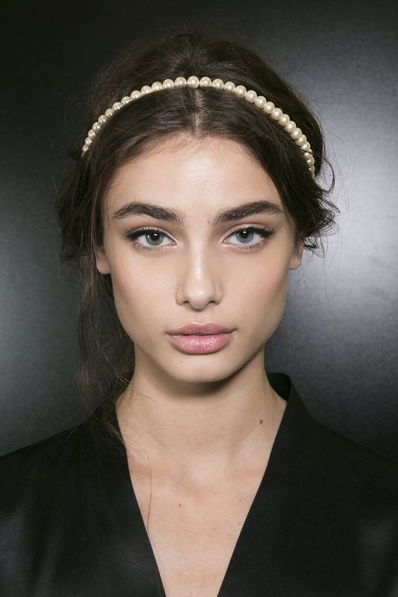 a messy wavy updo plus a pearl headband are perfect for a refined and effortlessly chic look