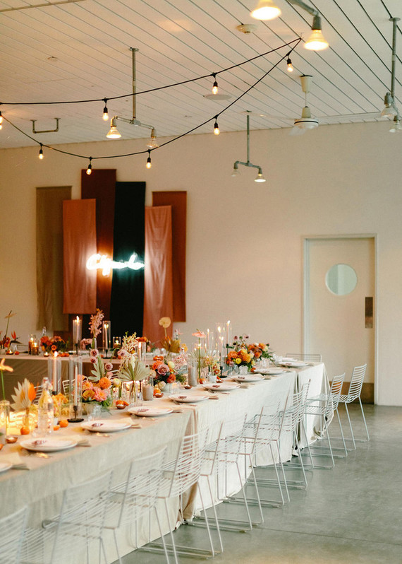 The wedding tablescapes were done with neutral linens, bright blooms, candles   colored and not