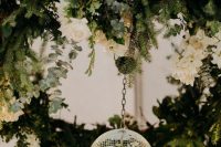 07 a greenery, fir, white rose wedding chandelier with a hanging disco ball is a unique idea for wedding decor