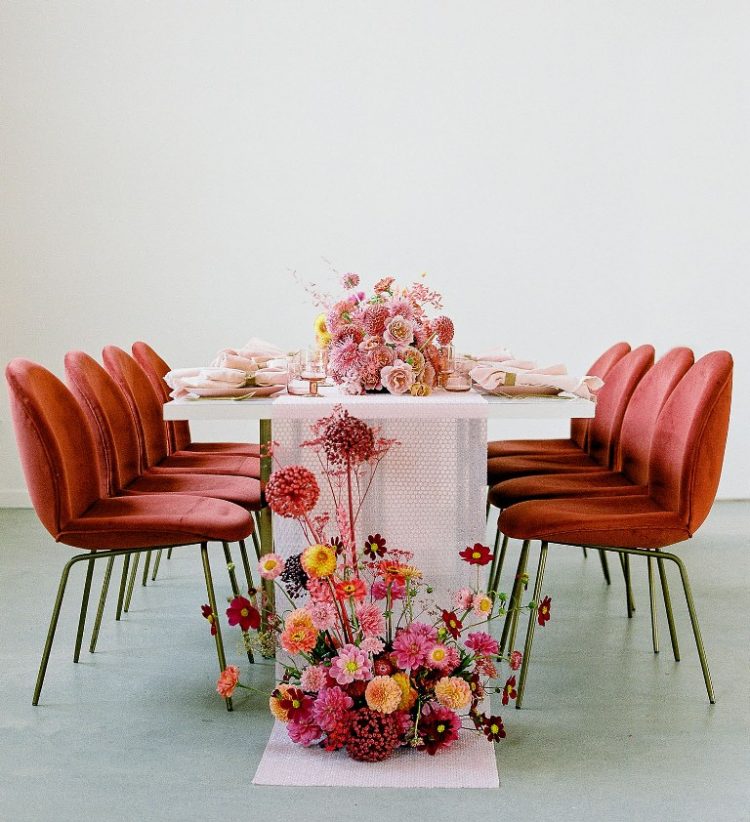 The wedding tablescape was done with pink and mustard blooms and a bold floral arrangement at the table