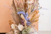 13 a wedding decor arrangement of pastel blooms, dried herbs and leaves, pampas grass and a disco ball