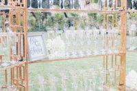 15 a glam metallic stand with glass shelves, white florals and glasses is a refined way to serve drinks