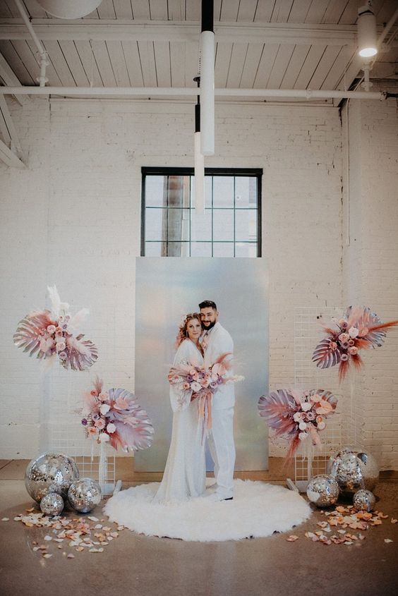 an iridescent backdrop, pastel blooms and leaves, a faux fur rug and disco balls for a one-of-a-kind wedding ceremony space