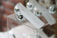 17 mini disco balls as wedding favors and as place card holders at the same time for a party-themed or a NYE wedding