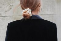 20 a simple low bun accented with a large pearl hair tie for a modern or very casual bride