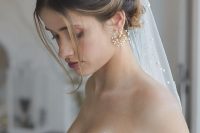 21 a stylish updo with waves and some locks down, pearl pins of various sizes and a pearl embellished veil, statement pearl earrings