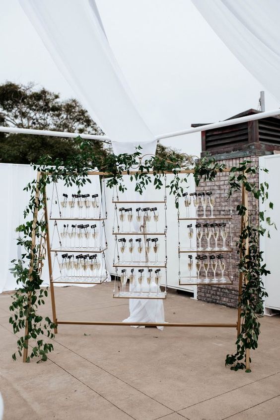 a glam swing with hanging glass shelves and drinks plus greenery all around is very creative