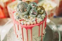 26 a party-themed wedding cake with pink drip, sparkles, beads and disco balls on top is a very bright idea