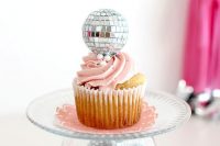27 a stand of a bowl with disco balls, a sheer plate and a cupcake topped with a disco ball for a party feel