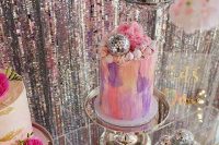 28 an arrangement of bold painted wedding cakes topped with fresh blooms and disco balls looks super cool