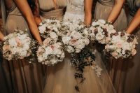 Bridesmaids chose bouquets with white and pale pink roses and a greenery
