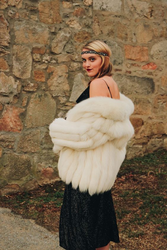 a black sequin dress and a white faux fur bridal coat for a bold and catchy 20s inspired look