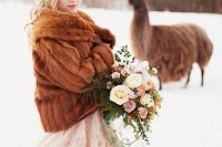 a blush wedding dress paired with a brown faux fur jacket create a lovely and chic look with a soft touch of color