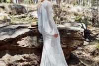 a boho lace A-line wedding gown with long sleeves with a bell touch and a cutout back covered with long fringe for a statement